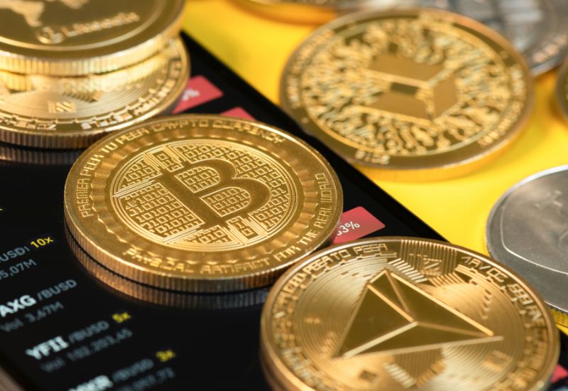 Golden Crypto Coins above Phone Display